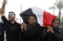 Mourners carry the coffin of a victim killed by a bomb attack in Baghdad's al-Bayaa district