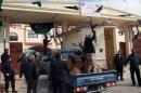 Libyan army guards and police celebrate outside the prison in Tripoli where one of the sons of late dictator Moamer Kadhafi, Saadi Kadhafi, arrived following his extradition from Niger on March 6, 2014