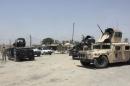 Iraqi security forces ride on vehicles during an intensive security deployment on the outskirts of Diyala