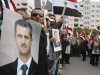 Pro-Syrian regime protesters, hold portraits of Syrian President Bashar Assad and shout slogans against the Arab League, as they gather outside the Syrian foreign ministry where Syrian Foreign Minister Walid al-Moallem helds a press conference, in Damascus, Syria, on Monday Nov. 14, 2011. Syria's foreign minister accused Arab states on Monday of conspiring against Damascus after the Arab League voted to suspend Syria's membership over the government's deadly crackdown on an eight month-old uprising. (AP Photo/Muzaffar Salman)