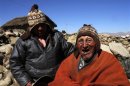 Aymara Indian Flores and his son joke during a Reuters TV interview in his hometown of Frasquia
