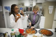 NASA's Advanced Food Technology Project manager Michele Perchonok, right, and Lockeed Martin Sr. Research Scientist Maya Cooper, try a pizza recipe being tested in a kitchen at Johnson Space Center Tuesday, July 3, 2012 in Houston, Texas. NASA is currently planning a mission to Mars, which has gravity, so more options for food preparation, like chopping vegetables, are available as opposed to the dehydrated fare of current space missions. (AP Photo/Michael Stravato)