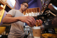 In this photo taken Thursday, April 19, 2012, barista Michael Bledsoe prepares a two-shot coffee drink in a coffee shop in Seattle. The college class of 2012 is in for a rude welcome to the world of work. A weak labor market already has left half of young college grads either jobless or underemployed in positions that don't fully use their skills and knowledge. (AP Photo/Elaine Thompson)