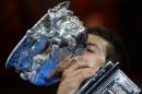 Novak Djokovic of Serbia kisses the trophy after defeating Andy Murray of Britain in the men's singles final at the Australian Open tennis championship in Melbourne, Australia, Sunday, Feb. 1, 2015. (AP Photo/Rob Griffith)