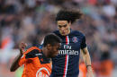 PSG's Edinson Cavani challenges for the ball with Yoann Wachter of Lorient during their League One soccer match in Lorient, western France, Saturday, Nov 1, 2014. Paris Saint germain won 2-1. (AP Photo/David Vincent)