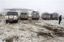 Emergencies Ministry vehicles and ambulances are parked near the site of the plane crash outside Almaty