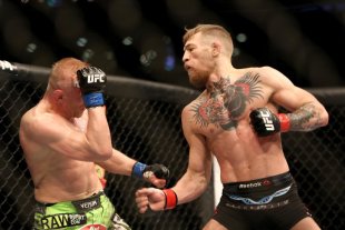 Conor McGregor delivers a punch to Dennis Siver during their fight. (AP)