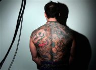 A man poses, showing the tattoos on his back, at the International London Tattoo convention October 6, 2006. REUTERS/Luke MacGregor