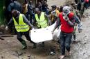 Volunteers carry a body retrieved from the rubble at the site of a building collapse in Nairobi, Kenya, Saturday, April 30, 2016. A six-story residential building in a low income area of the Kenyan capital collapsed Friday night under heavy rain and flooding, killing at least seven people and injuring over 100 others, Kenyan officials said. (AP Photo/Sayyid Abdul Azim)