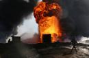 Thick smoke rises from a fire which broke out at oil wells set ablaze by Islamic State militants before fleeing the oil-producing region of Qayyara