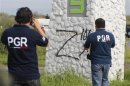 Federal agents take photographs of a sprayed "Z", the symbol of Zetas drug cartel, on a pillar at a crime scene in the municipality of Cadereyta
