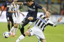 Inter Milan defender Yuto Nagatomo, left, of Japan, is tackled by Udinese defender Silvan Widmer, of Switzerland, during the Serie A soccer match between Inter Milan and Udinese at the San Siro stadium in Milan, Italy, Thursday, March 27, 2014. (AP Photo/Antonio Calanni)