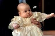 Britain's Prince William holds his son, Prince George as he arrives at Chapel Royal in St James's Palace in central London for the christening of the three month-old baby on October 23, 2013