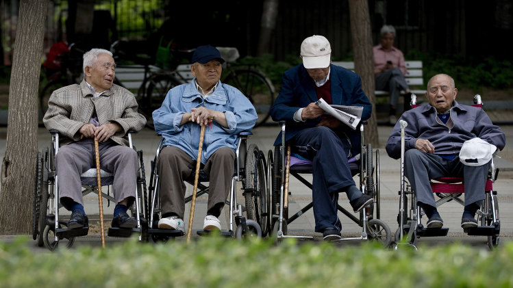 In this Thursday, May 23, 2013 photo, a group of elderly men take a rest on their wheelchairs at a park in Beijing. New wording in the law requiring people to visit or keep in touch with their elderly parents or risk being sued came into force Monday, July 1, 2013, as China faces increasing difficulty in caring for its aging population. (AP Photo/Andy Wong)