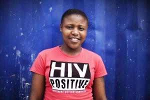 Nandi Makhele poses for a portrait while wearing a T-shirt indicating that she is HIV-positive in Cape Town