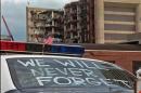 FILE - In this April 24, 1995 file photo, an Oklahoma City police car decorated with the words "We will never forget" and a small American flag sits near the Alfred P. Murrah Federal Building in Oklahoma City. On Thursday, July 31, 2014, the FBI capped off its attempt to persuade a federal judge in Salt Lake City that it is not hiding unreleased surveillance videos from the 1995 Oklahoma City bombing by bringing witnesses who testified that there has never been any security-camera videos of the bomb going off. (AP Photo/Rick Bowmer, File)