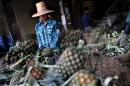 A worker checks a pineapple at a market in Bangkok on June 15, 2009