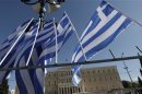 Greek flags fly in front of the parliament building during a rally in central Athens