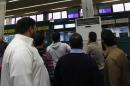 Passengers look at a flight information monitor after the reopening of the airport in Tripoli