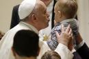 Pope Francis kisses a child as he meets with the participants at the missionary meeting of the Italian bishops' conference in the Paul VI hall at the Vatican, Saturday, Nov. 22, 2014. (AP Photo/Gregorio Borgia)
