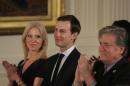Senior staff at the White House Kellyanne Conway, Jared Kushner and Steve Bannon applaud before being sworn in by Vice President Mike Pence in Washington