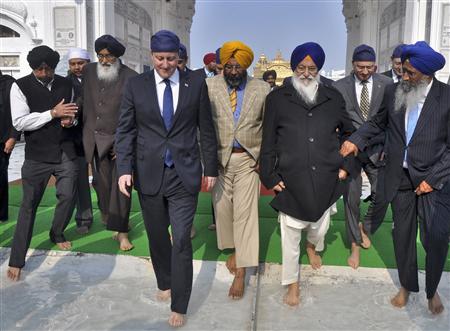 Britain's Prime Minister David Cameron (4th R) walks inside the premises of the holy Sikh shrine of Golden temple in the northern Indian city of Amritsar February 20, 2013. REUTERS/Munish Sharma