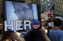 A demonstrator holds a sign with a photograph of former U.S. spy agency NSA contractor Edward Snowden and the word "HERO" during Fourth of July Independence Day celebrations in Boston