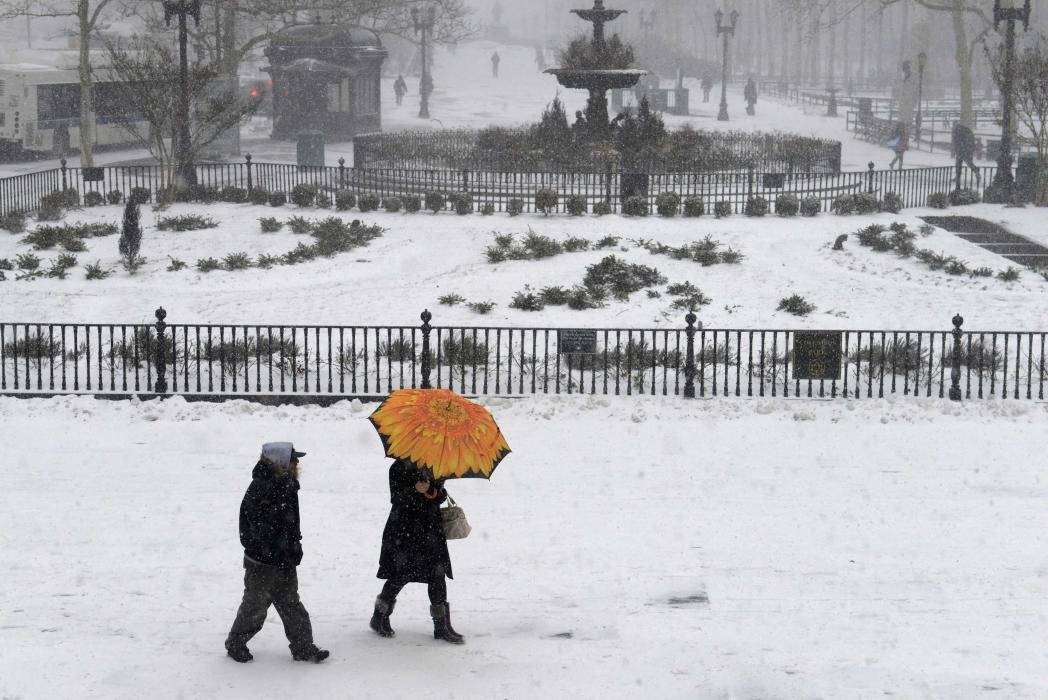 People walk in the Borough Hall section of downtown Brooklyn in New York City in falling snow