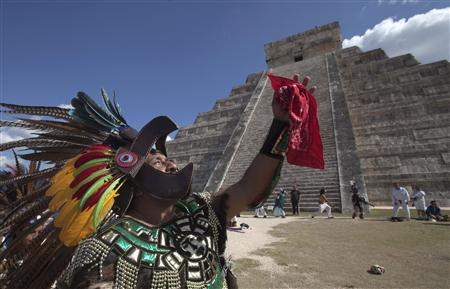 A man in Aztec warrior costume dances in front of the Pyramid of Kukulkan at Chichen Itza in Yucatan state, December 20, 2012. REUTERS/Victor Ruiz Garcia
