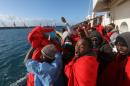 Migrants celebrate on board the former fishing trawler Golfo Azzurro as they arrive at the port of Pozzallo in Sicily