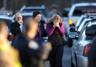 Residents grieve at the scene of a school shooting in Newtown, Connecticut. A young gunman slaughtered 20 small children and six teachers on Friday after walking into the school in an idyllic town with at least two sophisticated firearms