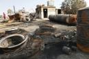 A man inspects damage at an oil refinery and a gas station that were targeted by what activists said were U.S.-led air strikes, in Tel Abyad