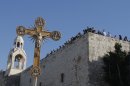 In this Friday, Dec. 24, 2010 file photo, a cross is seen backdropped by the Church of Nativity, traditionally believed by Christians to be the birthplace of Jesus Christ, during a Christmas parade in the West Bank town of Bethlehem. The Church of the Nativity in Bethlehem is becoming the church of contention with an unwelcome bid by the Palestinians to use their muscle as the newest members of the U.N.'s cultural arm and obtain World Heritage status for the iconic Christian site (AP Photo/Nasser Shiyoukhi, File)