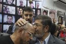 In this Sunday, June 3, 2012, photo, Egyptian Muslim Brotherhood presidential candidate Mohammed Morsi kisses the head of a man during a meeting with relatives of those killed and injured during last year's revolution that forced former Egyptian president Hosni Mubarak from power, in Cairo, Egypt. The Muslim Brotherhood has energized its powerful electoral machine, trying to rally the public behind its candidate for president in a tough race against former prime minister Ahmed Shafiq. (AP Photo/Ahmed Gomaa)