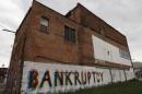 The word "Bankruptcy" is painted on the side of a building in Detroit, Michigan