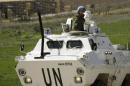 A member of the United Nations Interim Force in Lebanon stands on an armoured vehicle driving in the village of Marjayoun on March 15, 2014