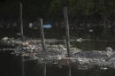 FILE - In this Feb. 28, 2015 file photo, trash floats on the water along a fence line in the Guanabara Bay in Rio de Janeiro, Brazil. The world governing body of sailing threaten Friday, April 24, 2015, to move events for the Rio 2016 Olympics out of the city's polluted Guanabara Bay unless "a whole lot more is done very quickly" to clear the venue of floating debris and sewage. (AP Photo/Leo Correa, File)