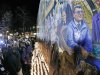People gather in front of a mural containing a likeness of former Penn State football coach Joe Paterno, right, at a candlelight memorial on the first anniversary of his death, Tuesday, Jan. 22, 2013, in State College, Pa. (AP Photo/Gene J. Puskar)