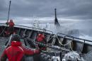 Crew members on Sea Shepherd vessel "The Bob Barker" react as Japanese whaling vessel Yushin Maru 3 crosses close to its bow in the Southern Ocean