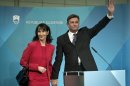 President elect, Slovenia's former prime minister Borut Pahor, right, with his spouse Tanja Pecar waves to the media in Ljubljana, Slovenia, Sunday, Dec. 2, 2012. Pahor, who has called for unity in the tiny EU nation amid growing discontent with government tax hikes and spending cuts, won the presidential election. (AP Photo/Darko Bandic)