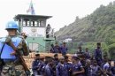 An U.N. Peacekeeper records a video of Congolese national police officers arriving on a ferry at a port at Lake Kivu