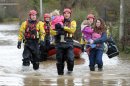 Crew Commander from Tewkesbury fire station Dave Webb carries 19-month-old daughter of Tina Bailey who carries her 3 year old daughter, after they were rescued from their house in Gloucester, England, Tuesday Nov. 27, 2012. Thousands of drivers and residents face further chaos today after heavy rain continued to fall across Britain overnight. (AP Photo/PA, Tim Ireland) UNITED KINGDOM OUT NO SALES NO ARCHIVE