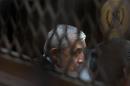 Guatemala's former president Otto Perez Molina, photographed through a window, sits in court for a third hearing on corruption allegations that led him to resign, in Guatemala City, Tuesday, Sept. 8, 2015. The court is considering allegations that Perez Molina was involved in a scheme in which businesspeople paid bribes to avoid import duties through Guatemala's customs agency. (AP Photo/Esteban Felix)