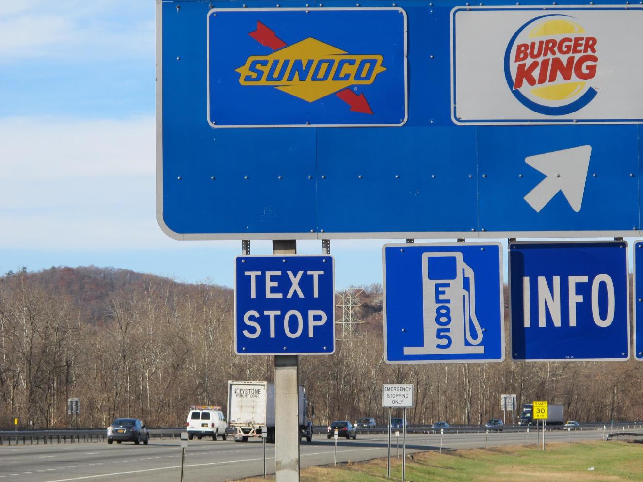A new "text stop" notification is seen on a sign for a service area on the New York State Thruway in Sloatsburg, N.Y., on Thursday, Nov. 14, 2013. A state crackdown on texting while driving includes designating many pull-off areas as text stops. (AP Photo/Jim Fitzgerald)