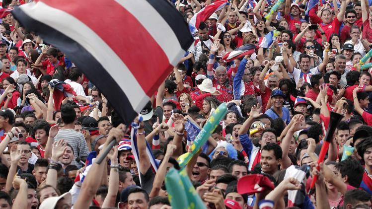 Costa Rica&#39;s fans celebrate after their team scored a goal against Greece as they watch a broadcast of their 2014 World Cup round of 16 game in San Jose