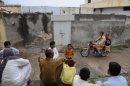 Pakistani residents gather outside the house of a Christian girl arrested on charges of blasphemy, in Islamabad