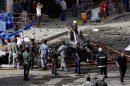 Security forces inspect the scene of a car bomb attack in the Baghdad, Iraq, Monday, May 27, 2013. A parked car bomb explosion in the busy commercial Sadoun Street in central Baghdad, killed and wounded scores of people, police said. (AP Photo/Khalid Mohammed)
