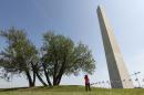A woman stops to photograph the re-opened Washington Monument in Washington