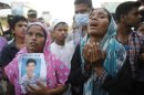 Relatives mourn as they show a picture of a garment worker, who is believed to be trapped under the rubble of the collapsed Rana Plaza building, in Savar