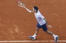 Federer of Switzerland hits a return to Devvarman of India during their men's singles match at the French Open tennis tournament in Paris